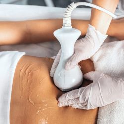 Shot of cosmetologist makes the procedure an ultrasonic cleaning of skin of a beautiful young woman on the spa center.